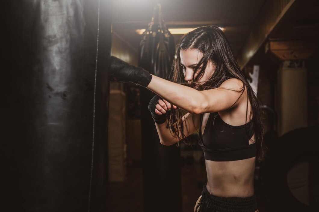 skinny-focused-woman-has-boxing-training-with-punching-bag-dark-gym_613910-12624.jpg